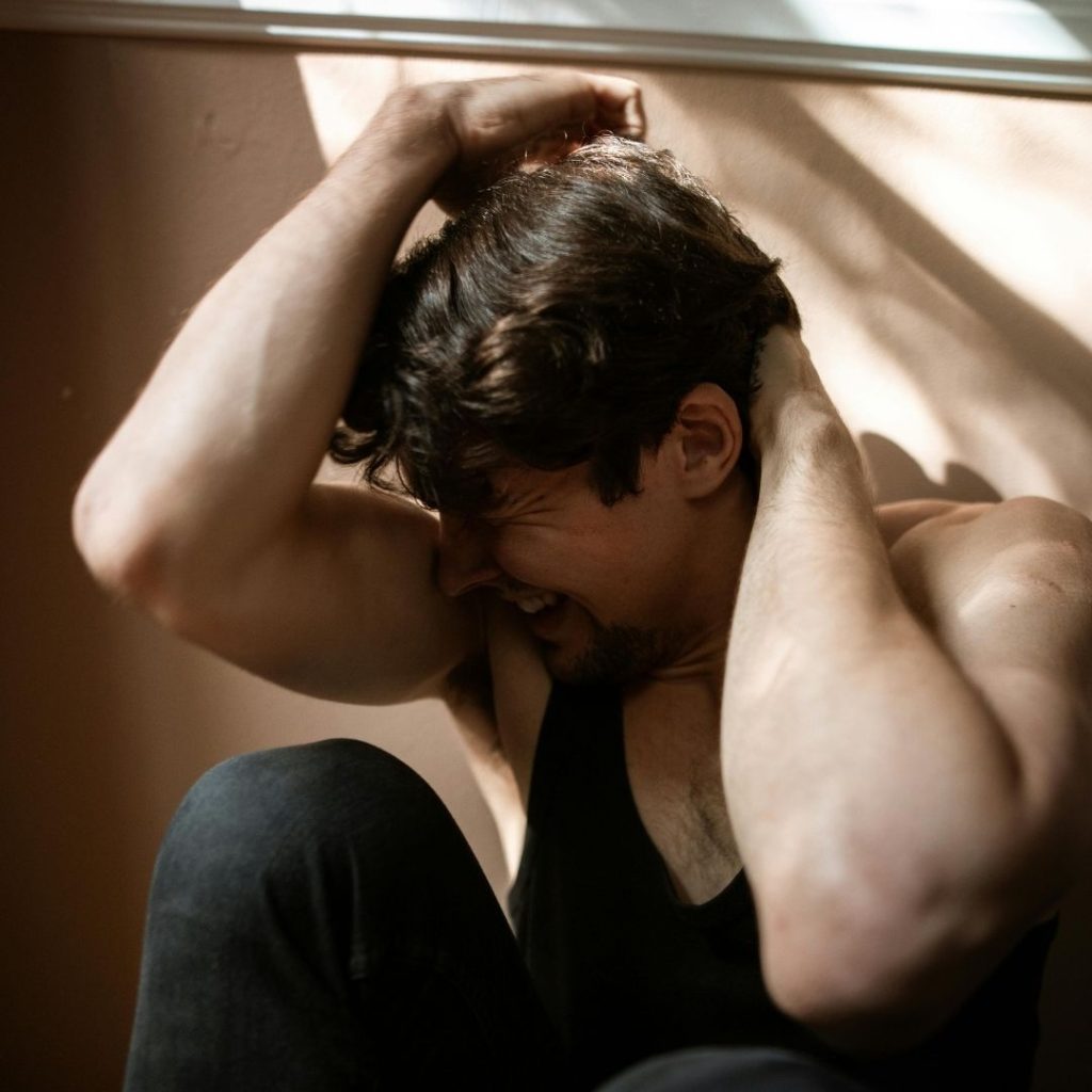 man with hands over head suffering ptsd