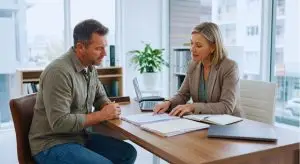 A man consults with his lawyer after sustaining an injury at work and being fired.