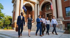 A group of attorneys and other people walk happily outside a courthouse.