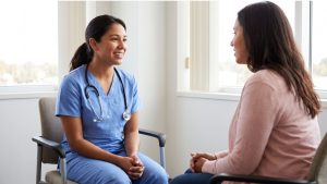 A nurse sitting and conversing with a professional advocate, showing an expression of relief.